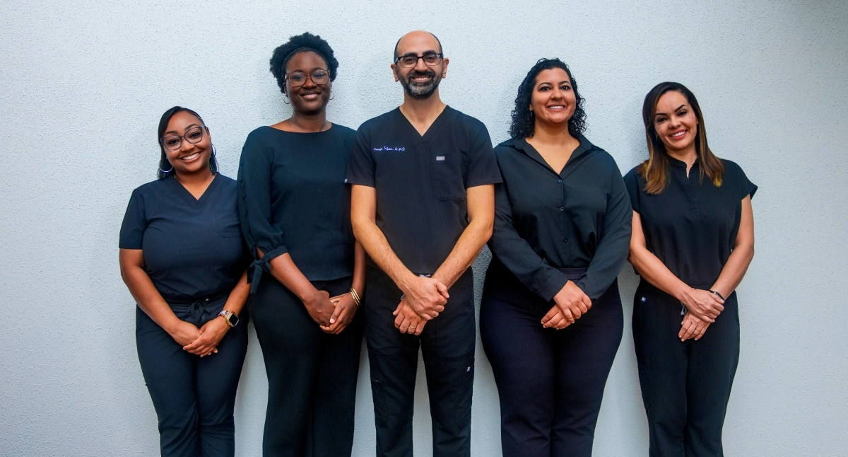 quality dentistry staff team standing together in medical scrubs at dental clinic